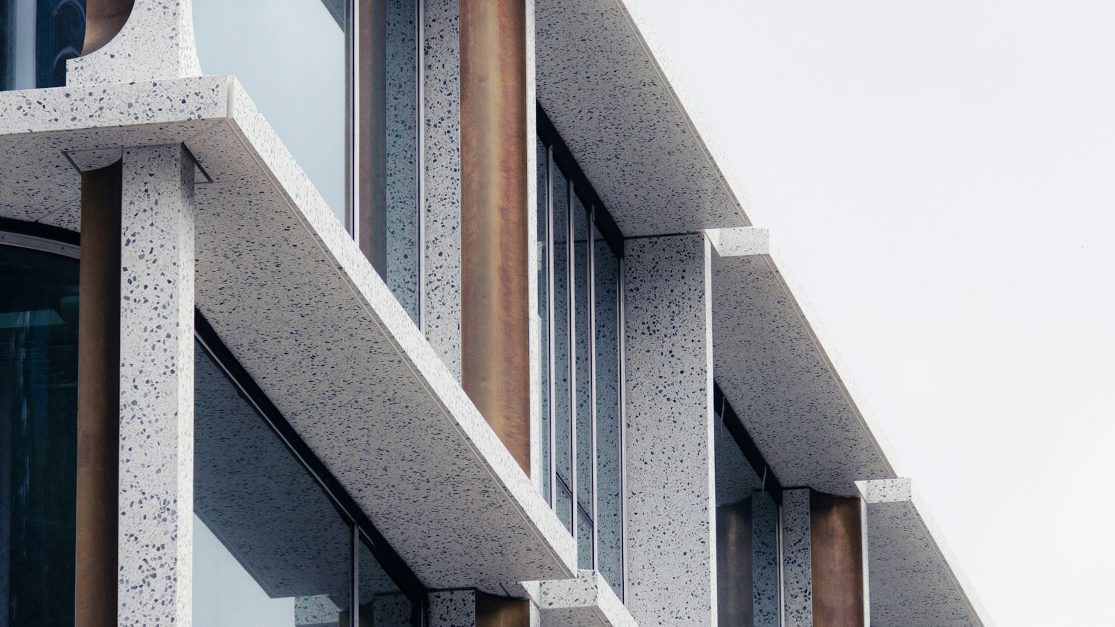 A tall modern building with rows of balconies and windows