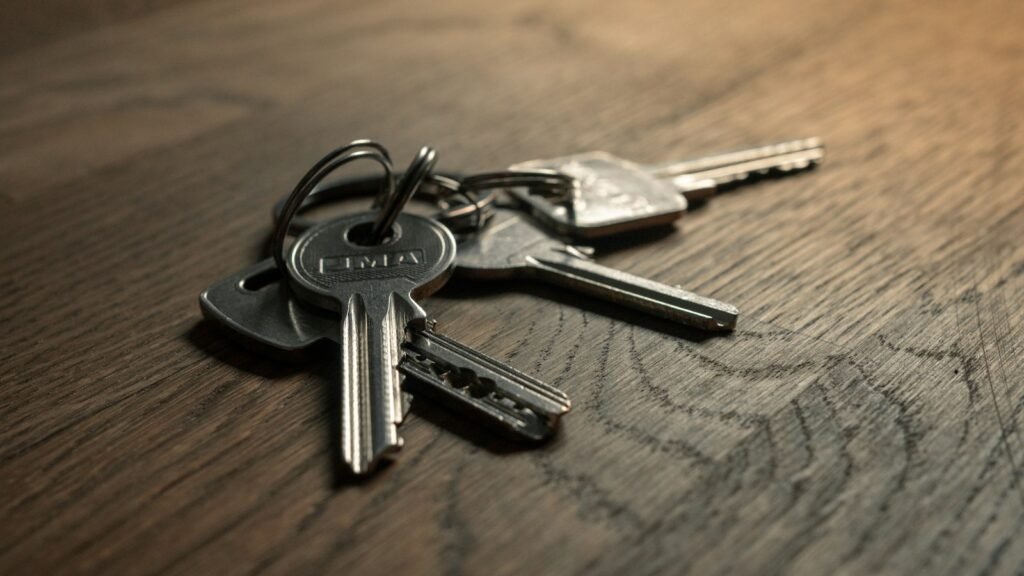 A set of office keys lying on a desk beside a notebook