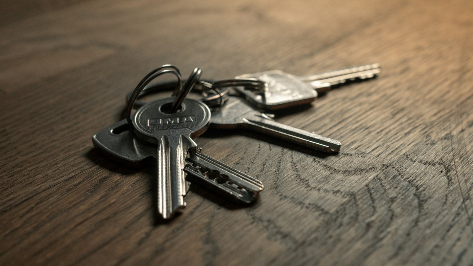 A set of office keys lying on a desk beside a notebook