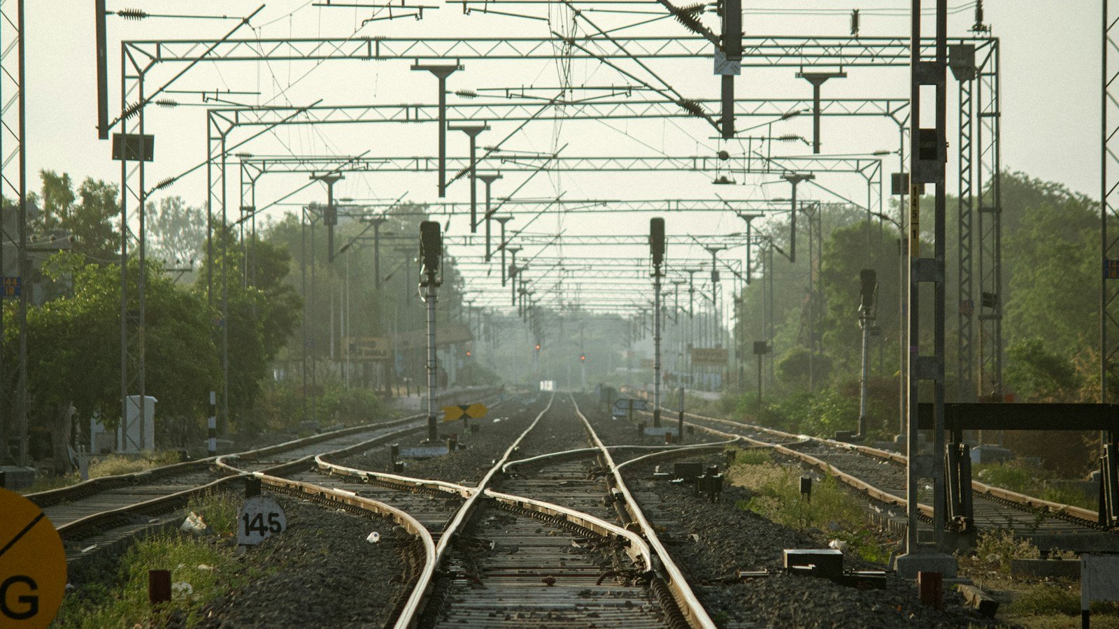 Railway tracks branching at a junction under overhead signal gantries