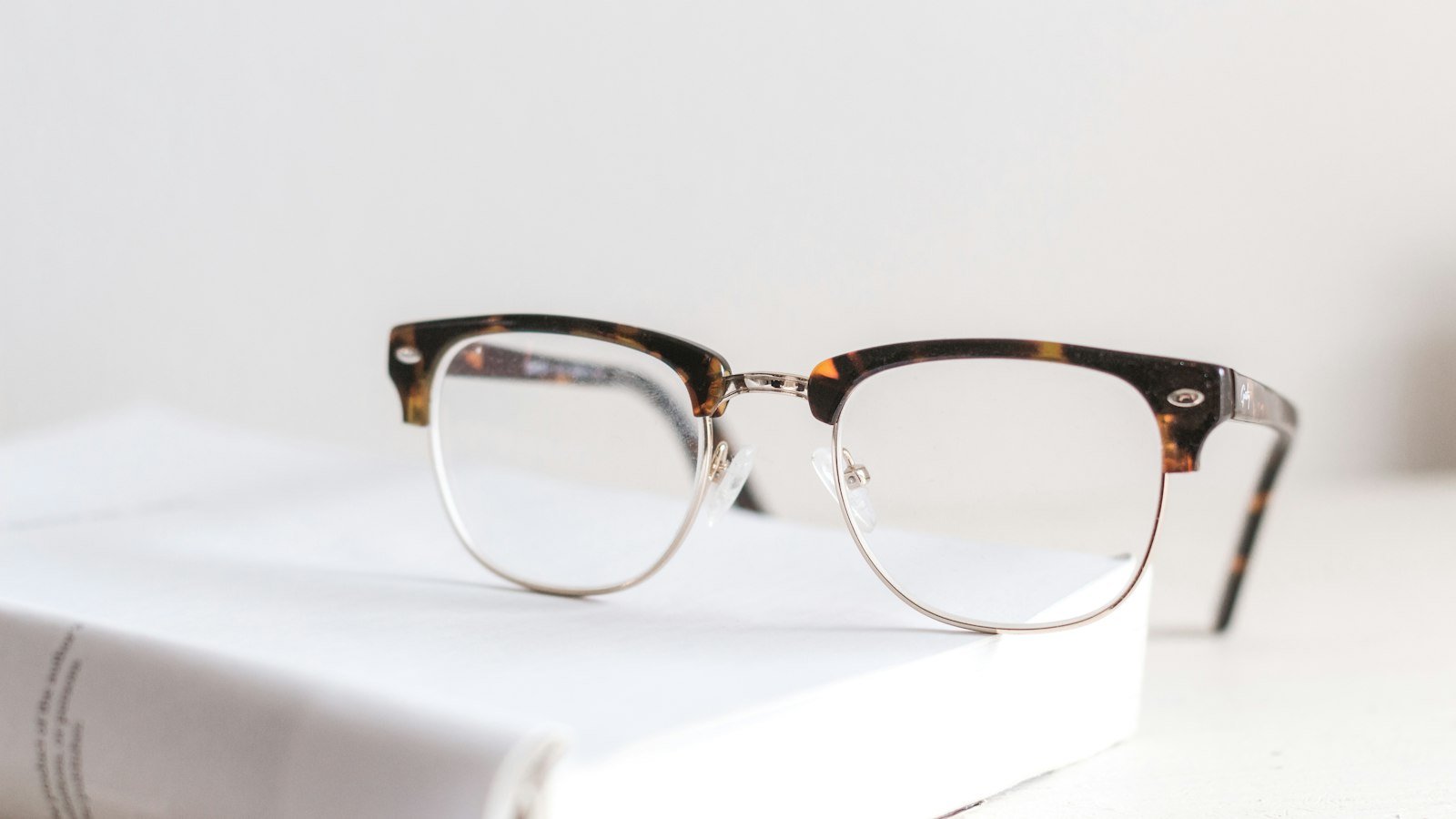A pair of reading glasses resting on an open book