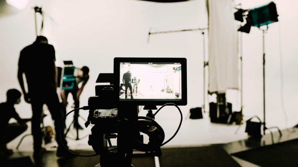 A camera on a tripod in a small, empty recording studio