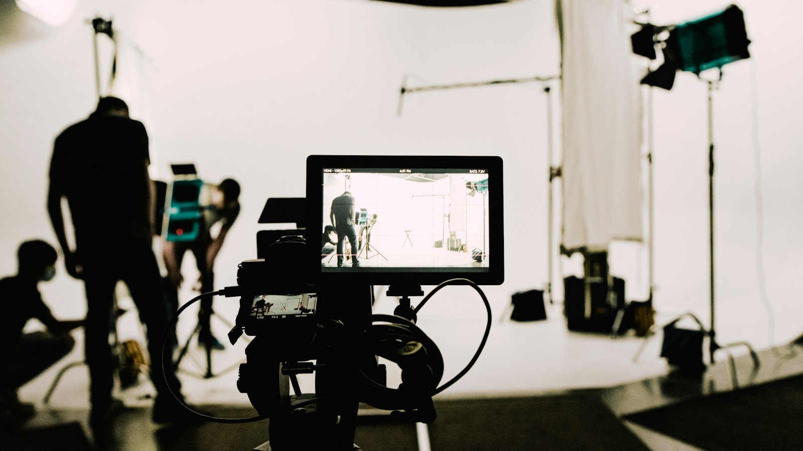 A camera on a tripod in a small, empty recording studio