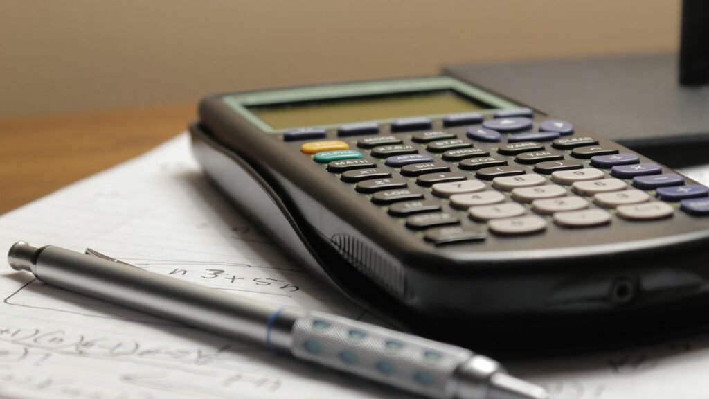 A calculator resting on an open ledger on a desk