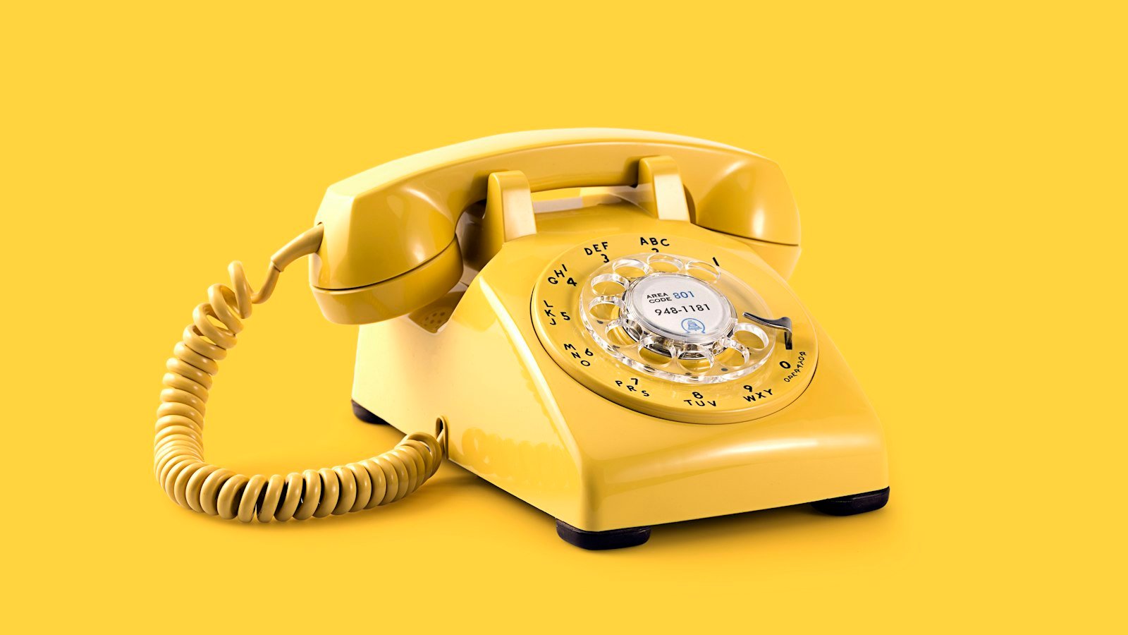 A yellow rotary telephone