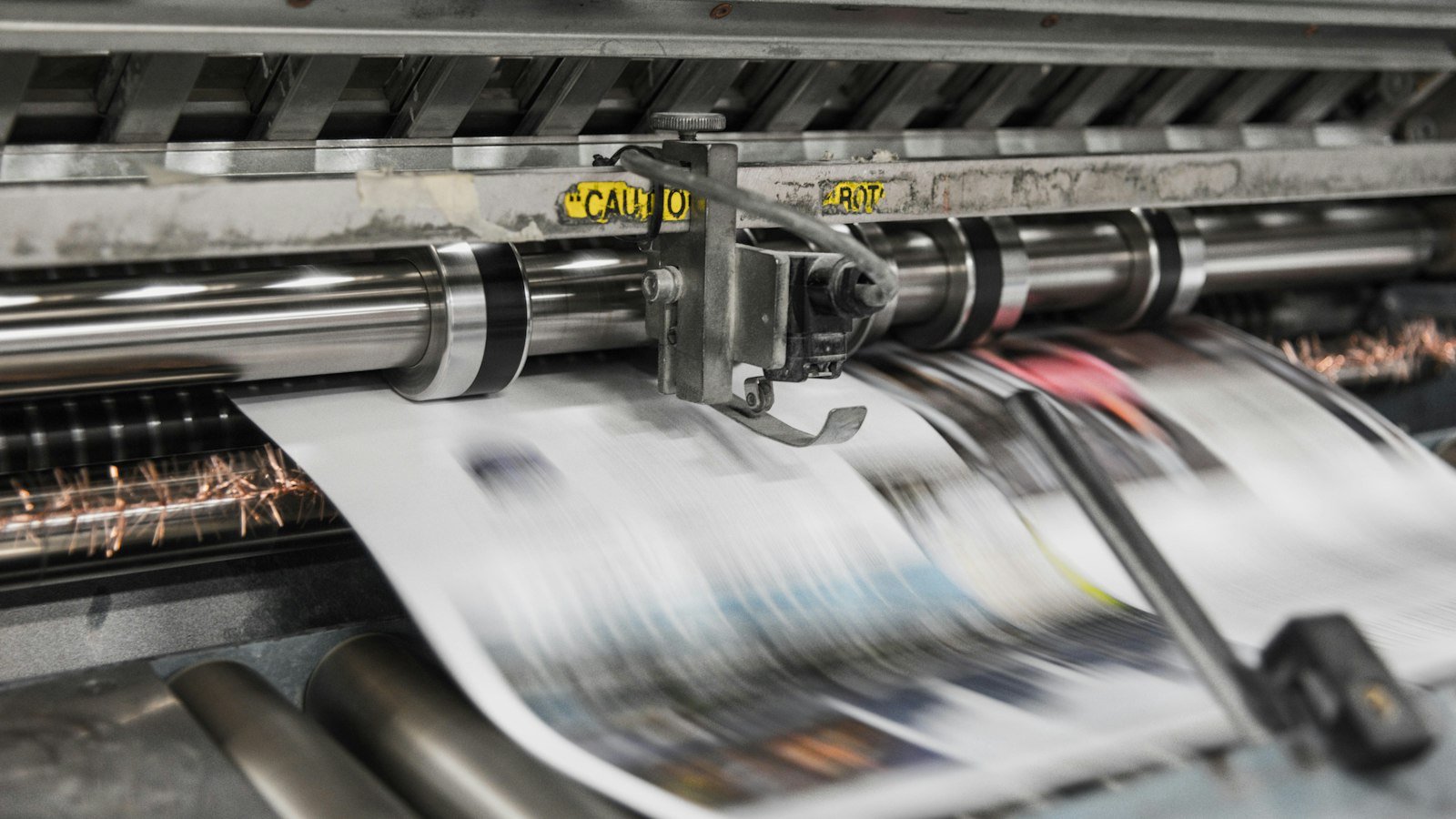 Newspapers moving through a printing press