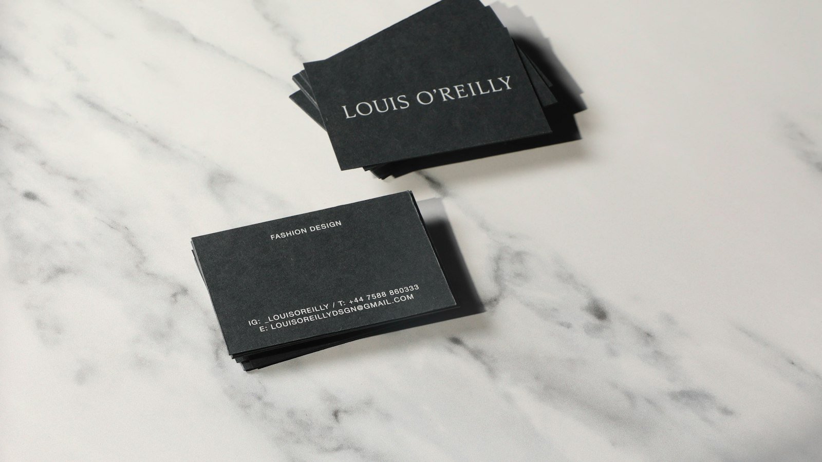 A pair of business cards on marble, representing doctor personal branding