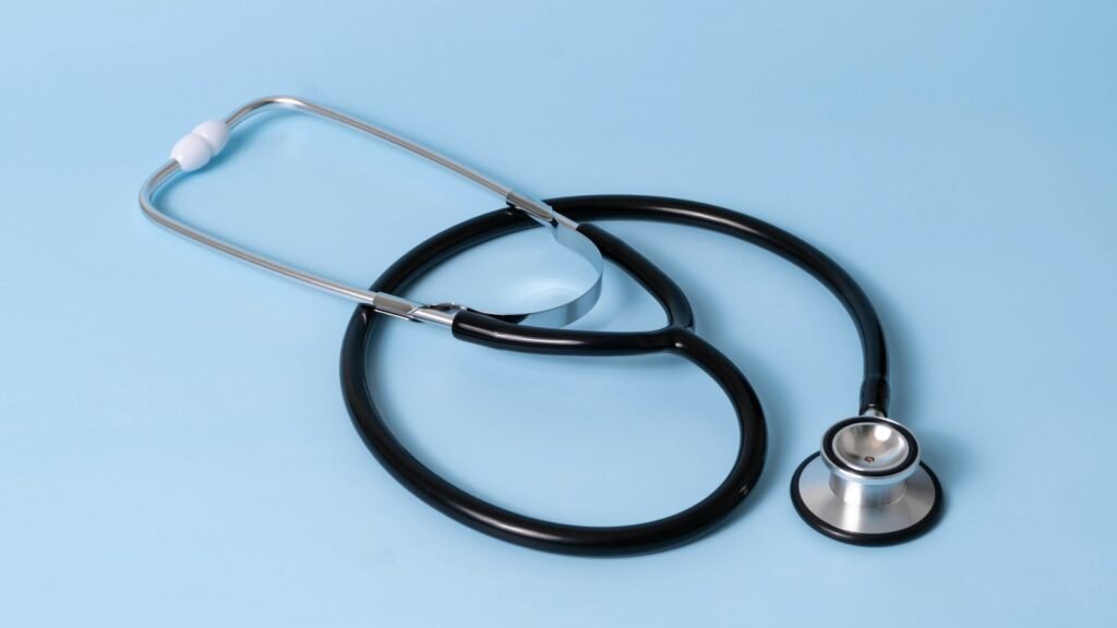 Stethoscope resting on a desk beside a blank nameplate