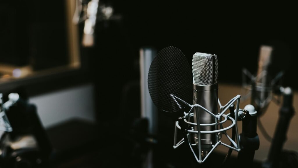A broadcast microphone on a desk in an empty radio studio