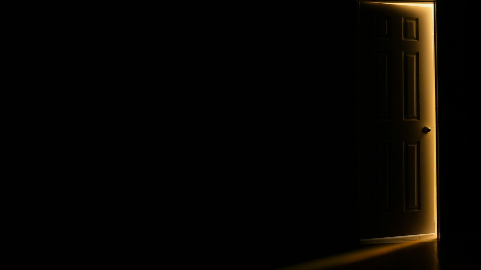 An open door letting light into a dark room