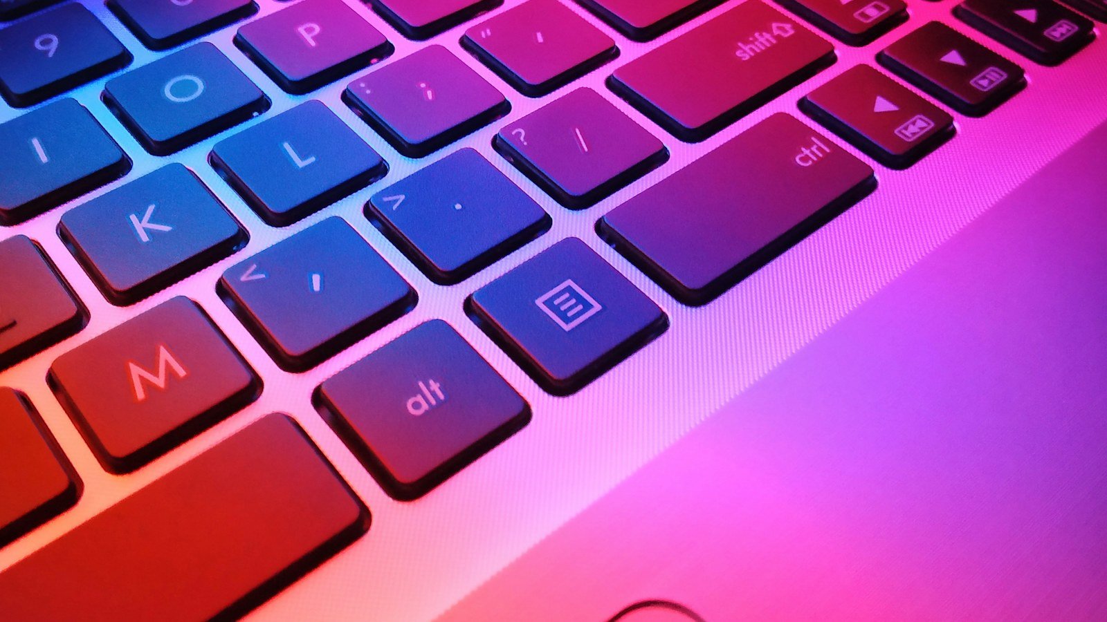Close up of a laptop keyboard lit in red and blue