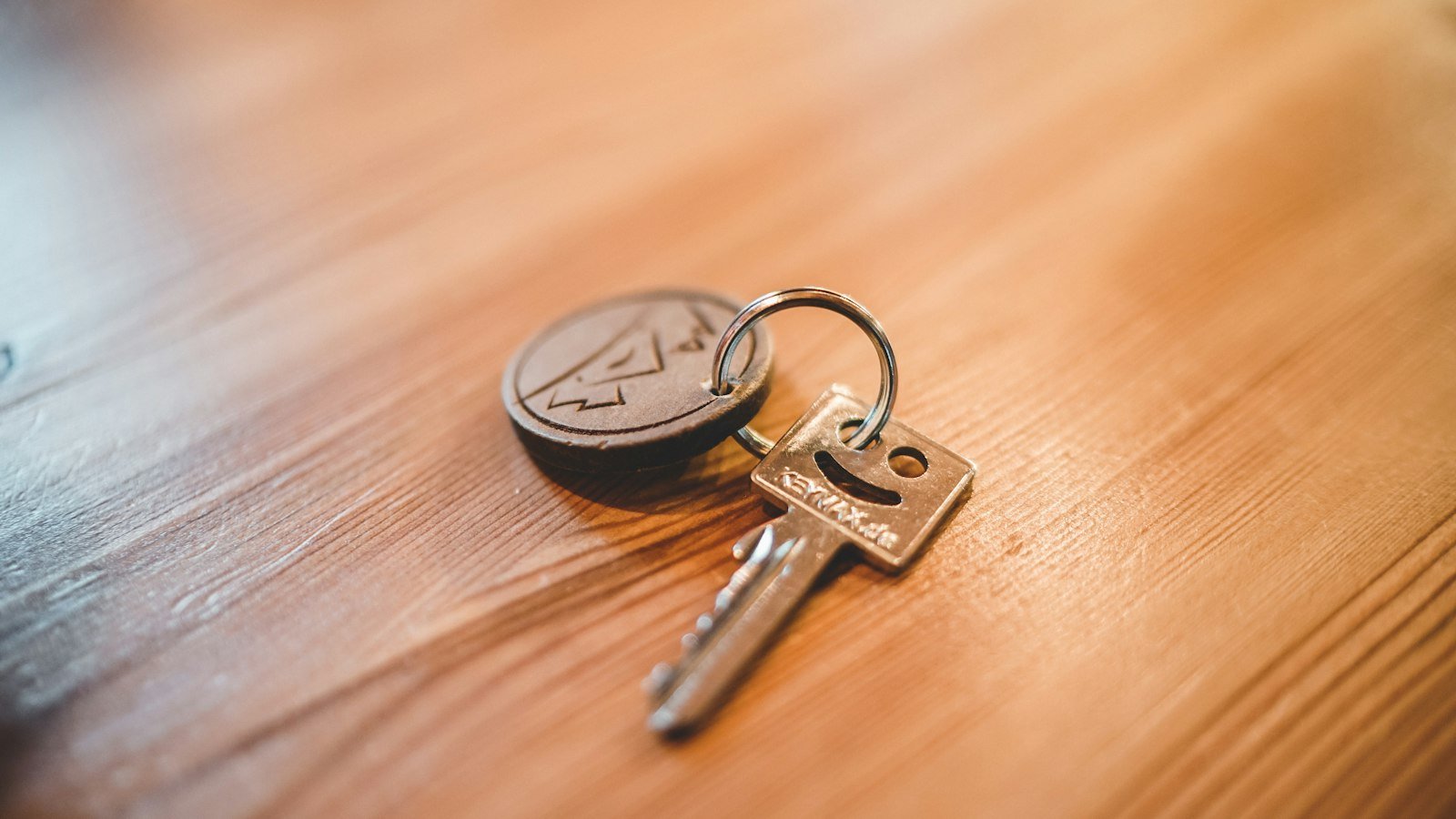 A single silver key resting on a table top
