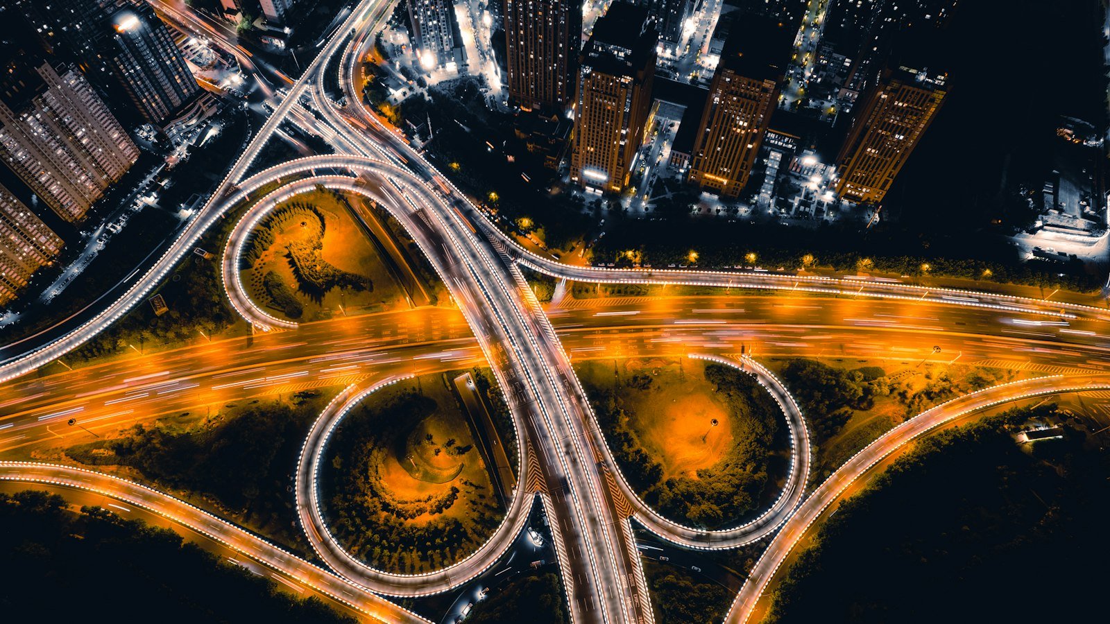 Aerial view of a city highway interchange lit amber at night
