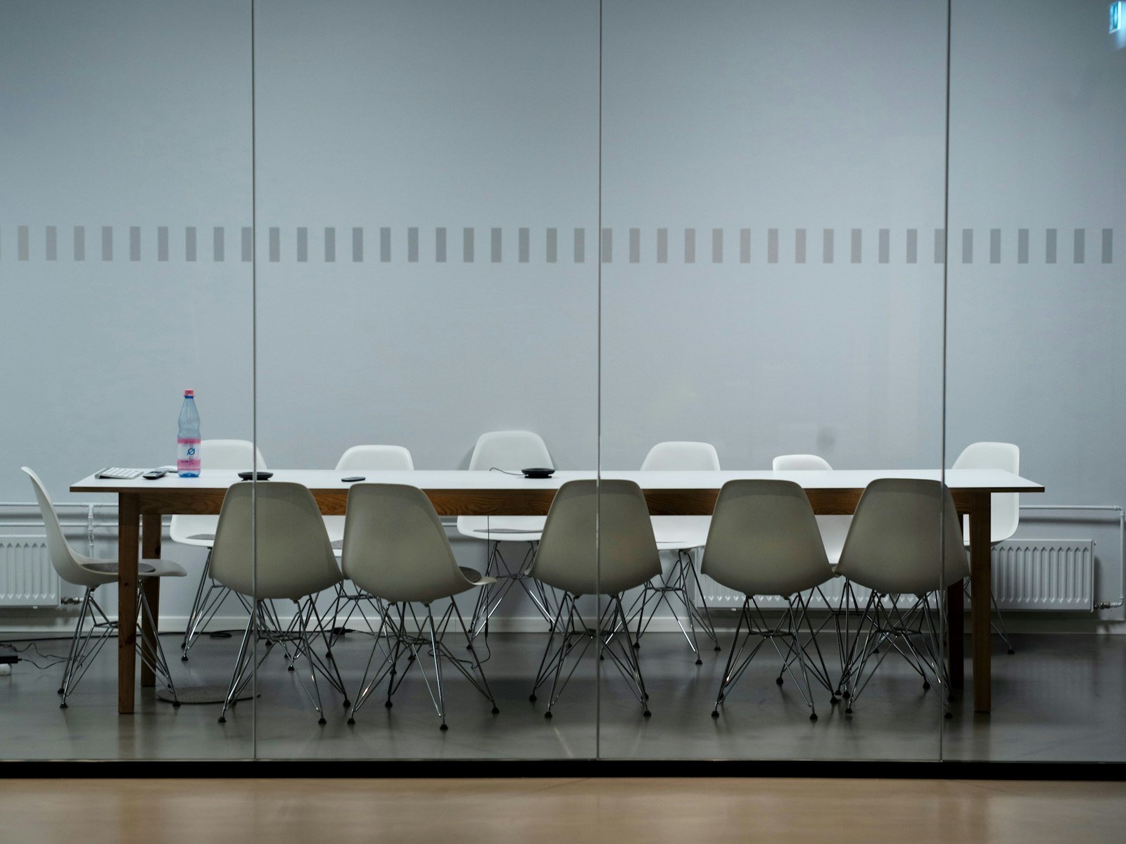 Empty glass boardroom with a long table and city skyline, representing the hospital CMO seat