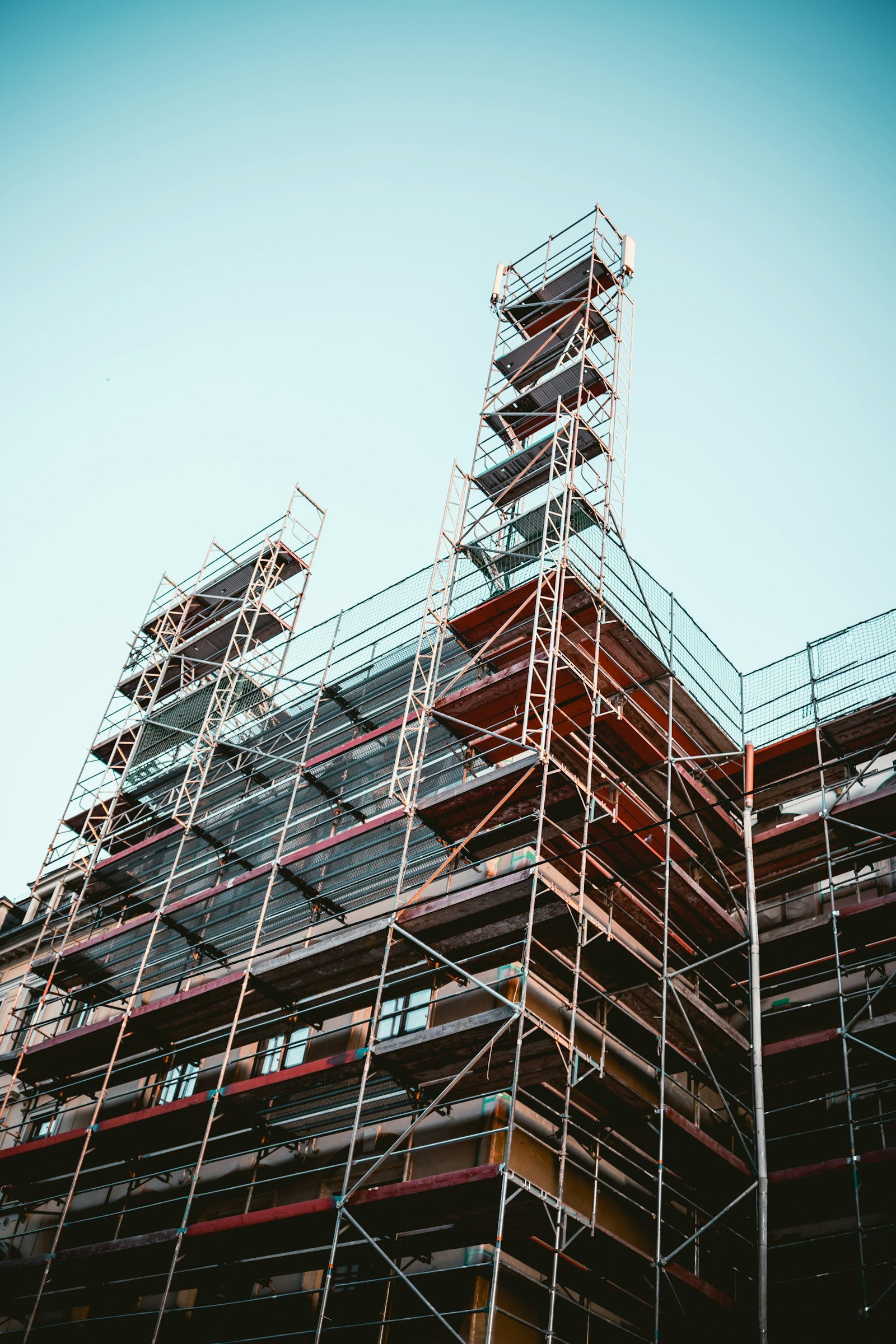 Scaffolding layered against a building facade, seen from below