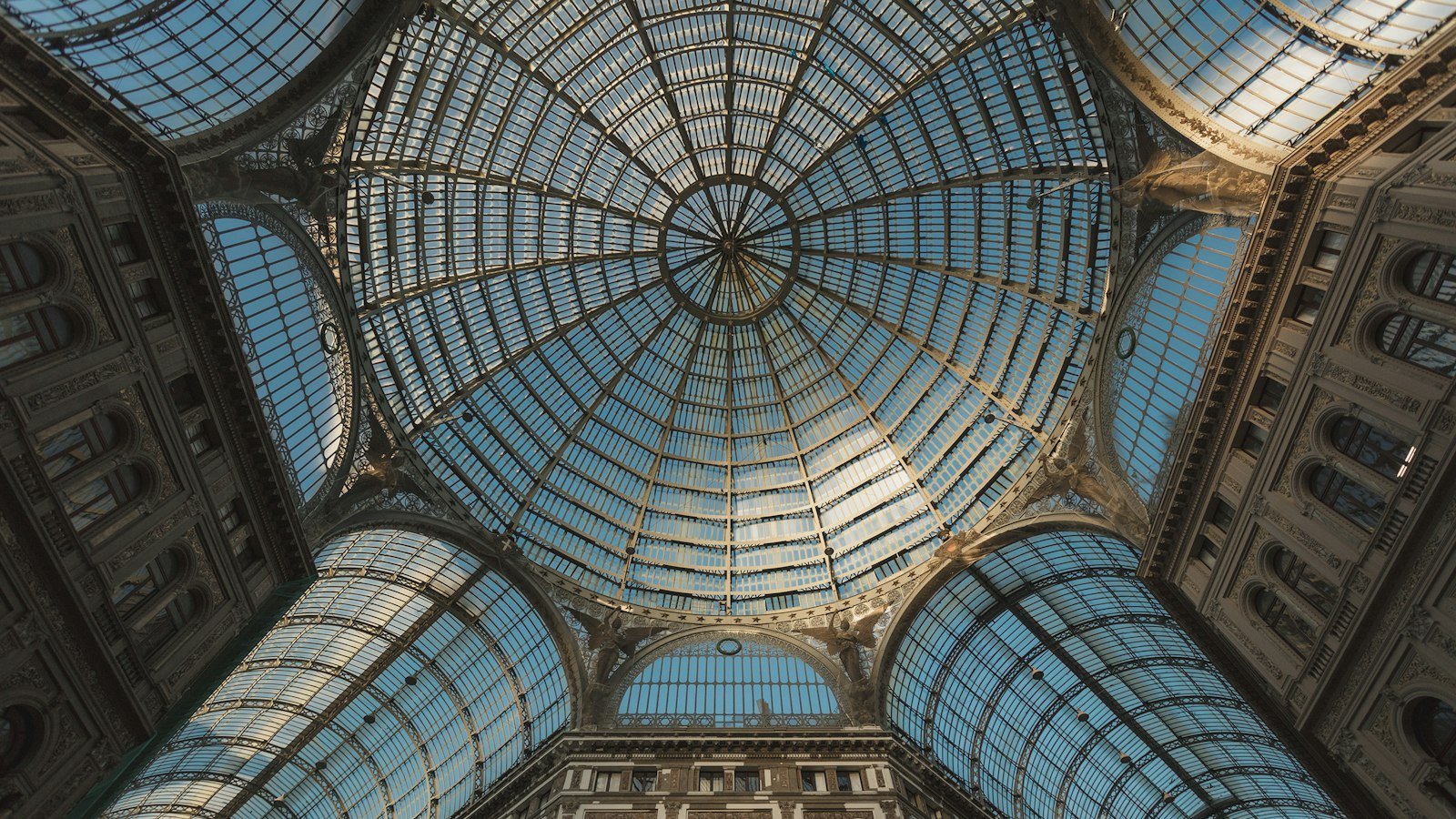 Looking up into a glass and iron dome ceiling