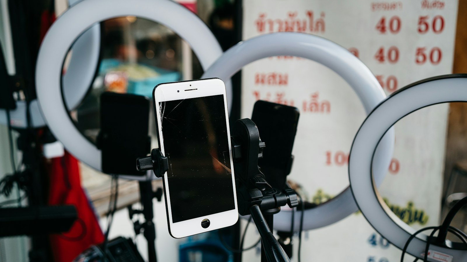 Smartphone mounted on a tripod beside a ring light