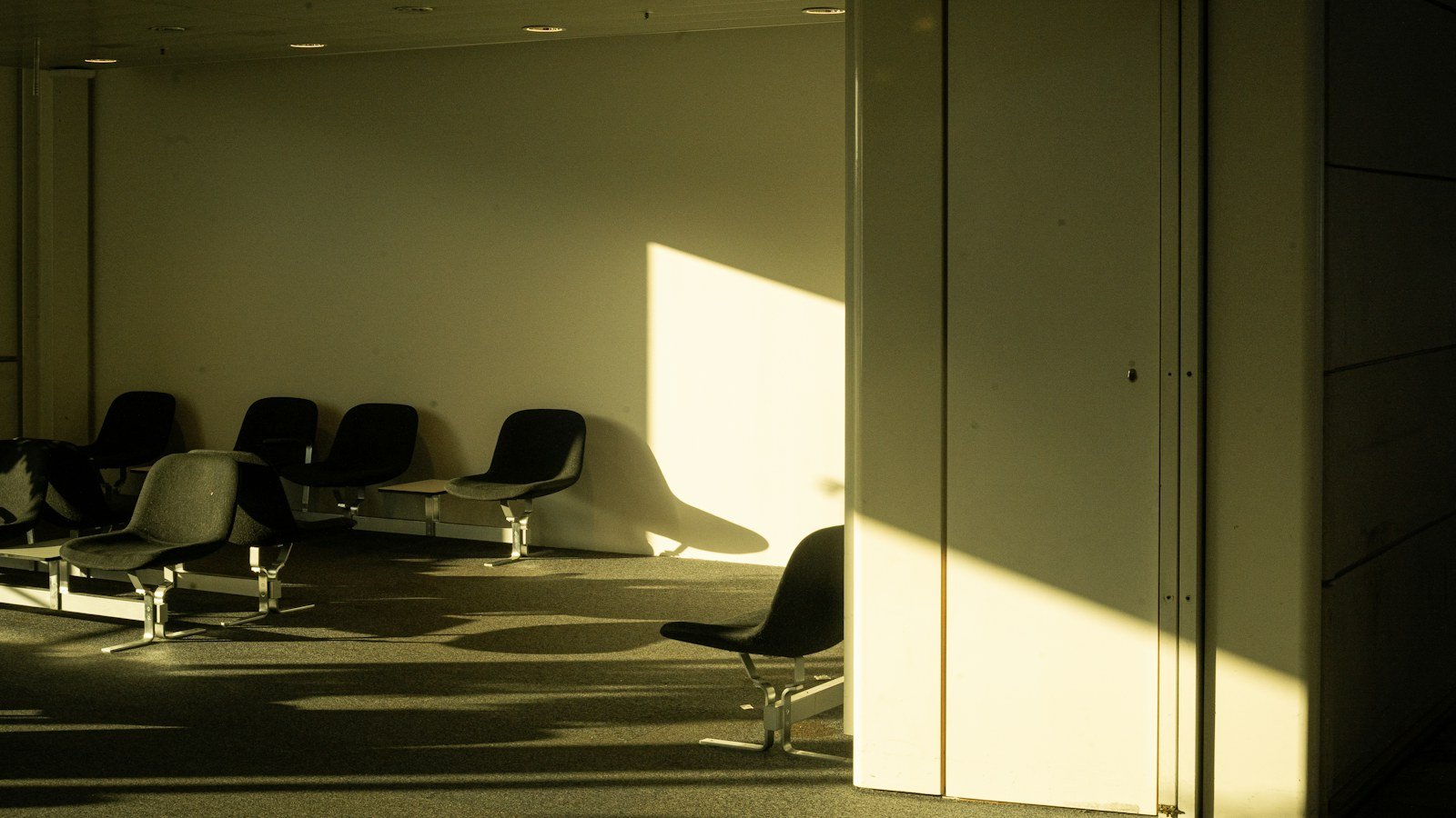 Empty seats in a quiet waiting area lit by afternoon sun