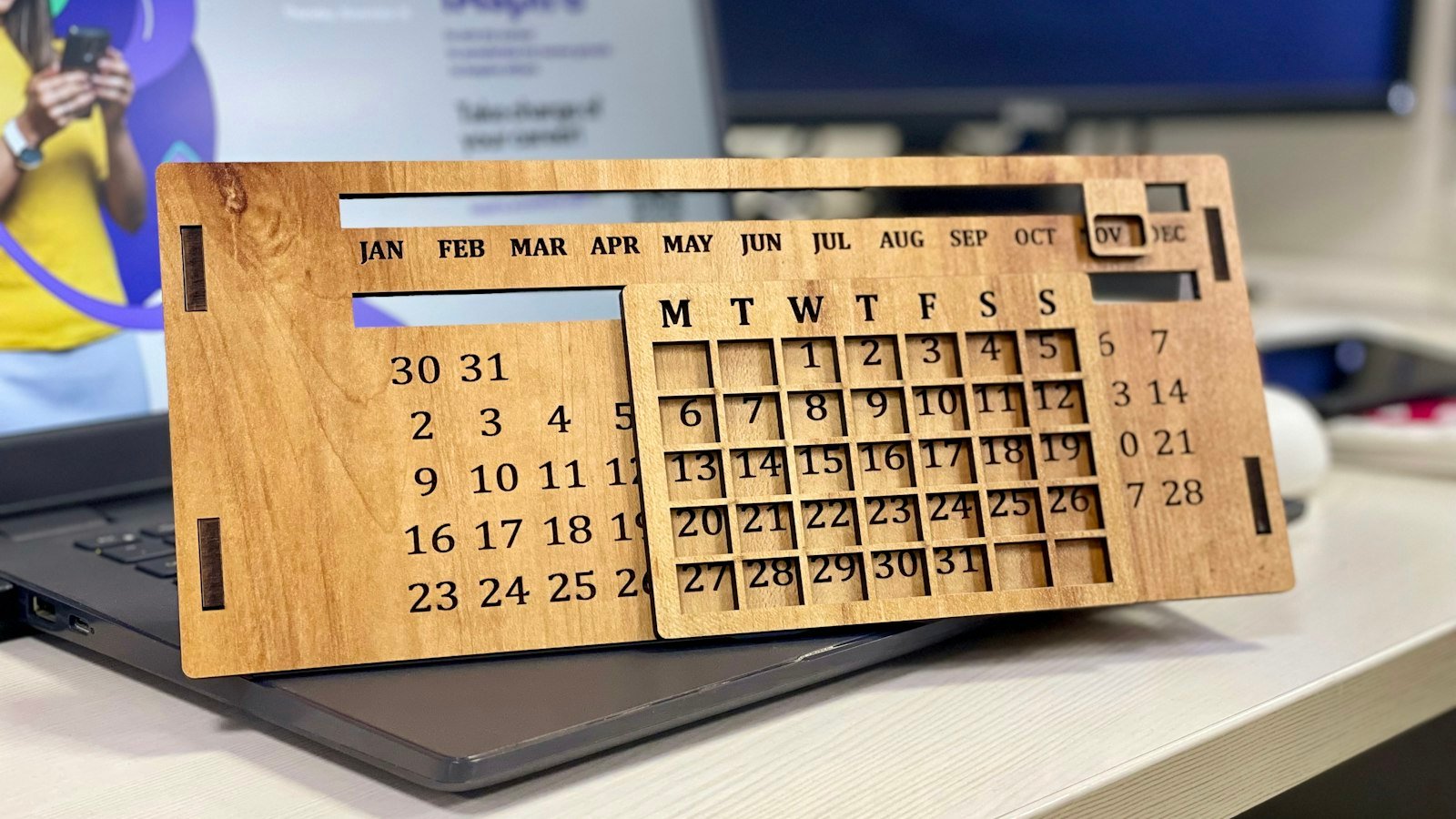 A smartphone showing a calendar app on a wooden desk