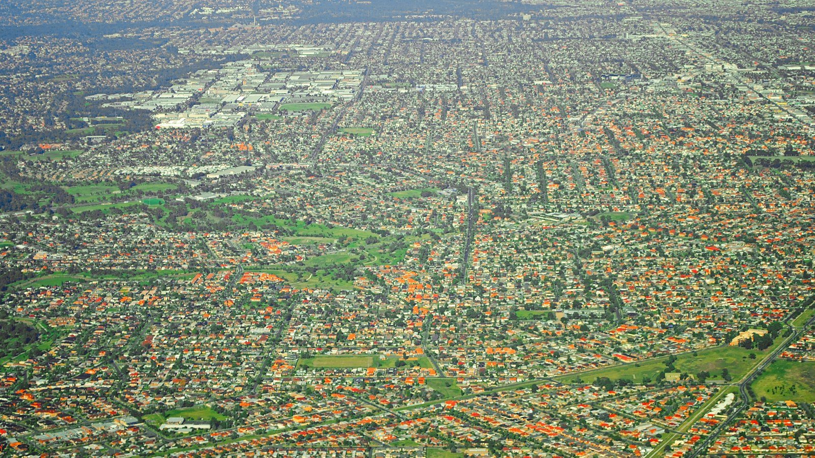 Aerial view of a dense residential neighbourhood with green open spaces