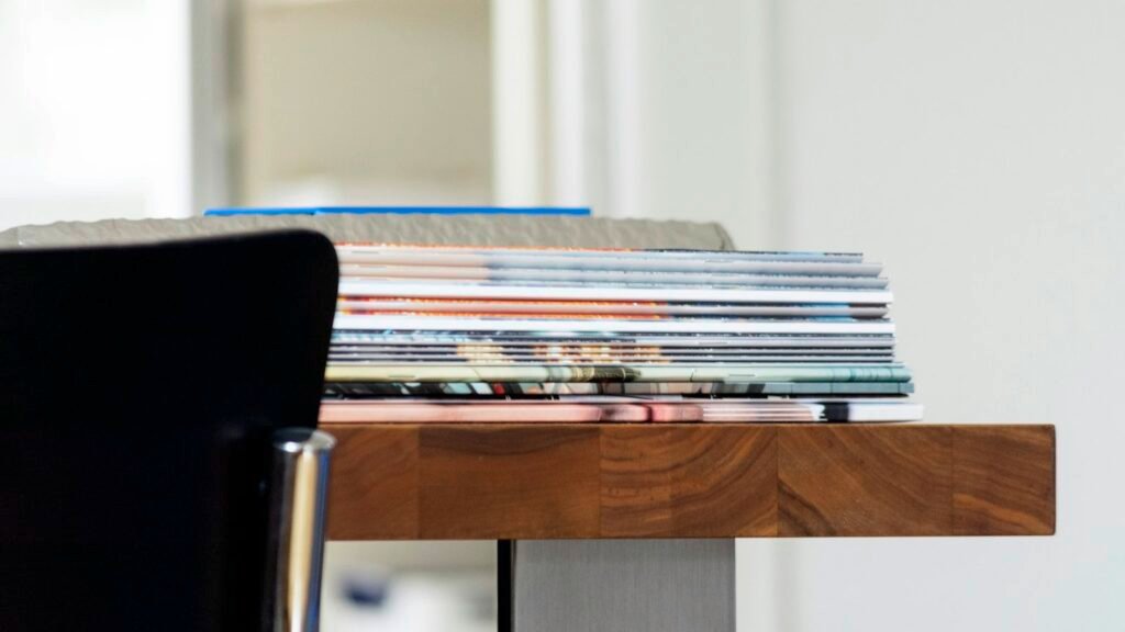 A stack of folded newspapers on a desk