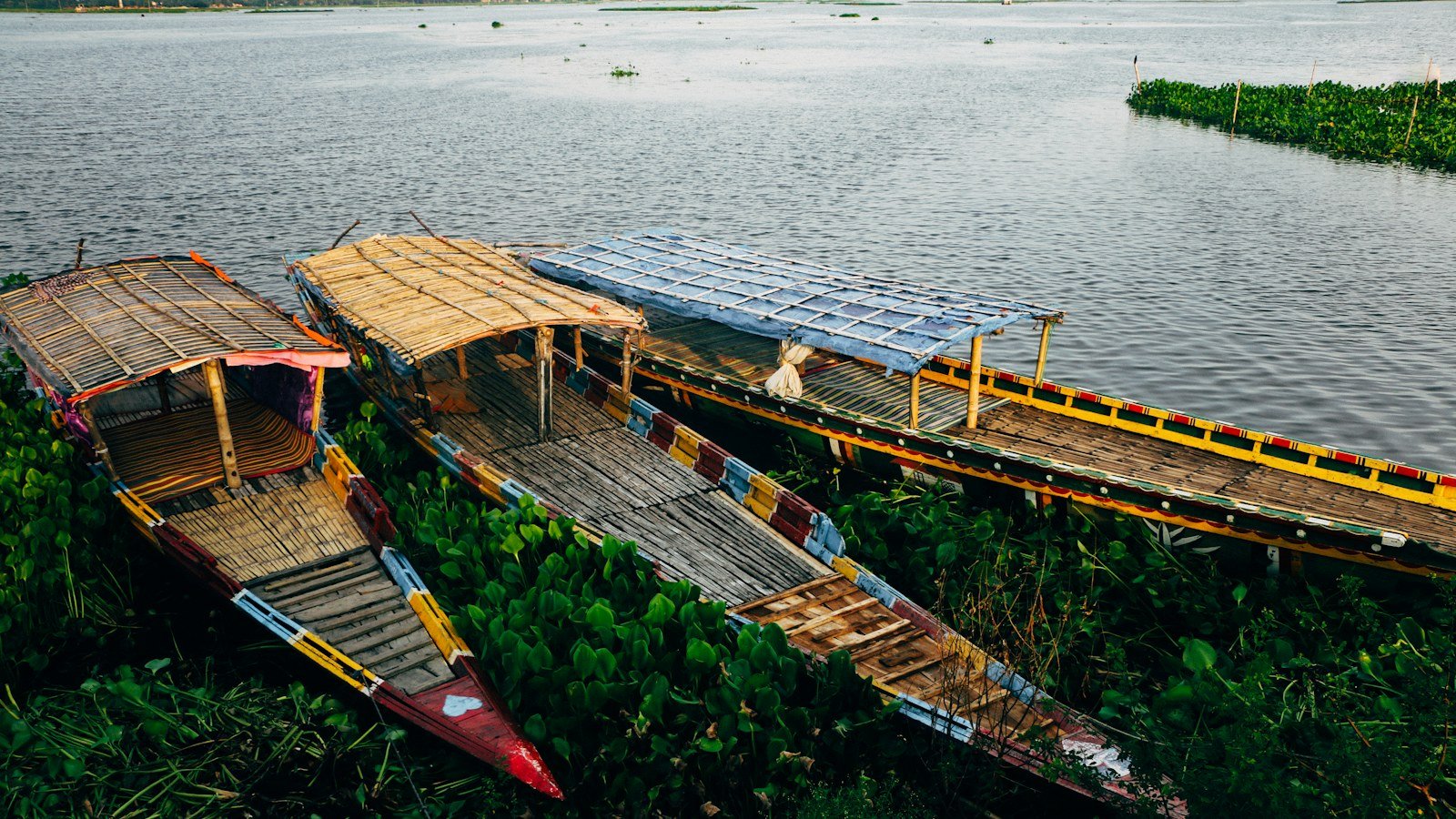 Many wooden boats moored close together in a busy river harbour