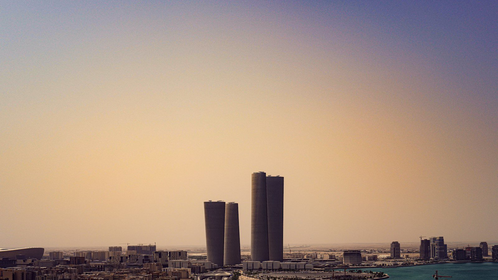 Tall city towers rising above a hazy skyline at dusk