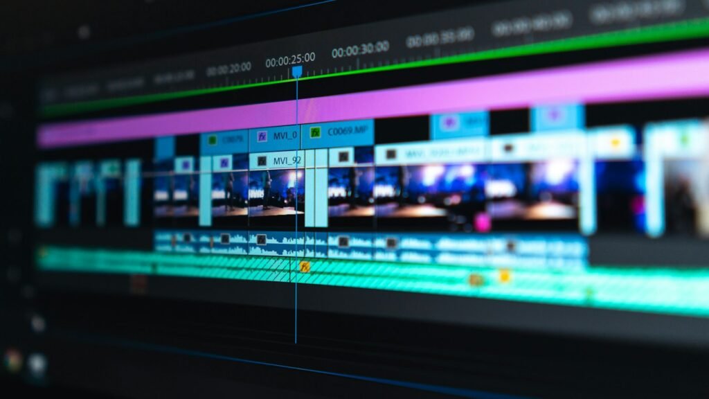 Computer monitor showing a video editing timeline on a desk