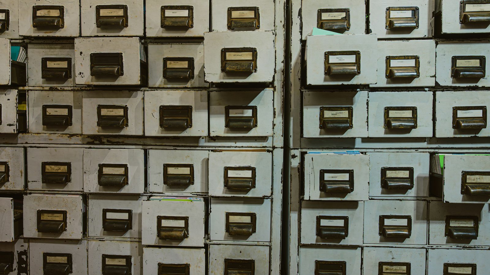 Row of labelled metal filing cabinet drawers