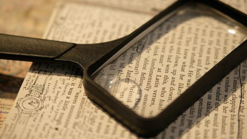 A magnifying glass resting on a folded newspaper