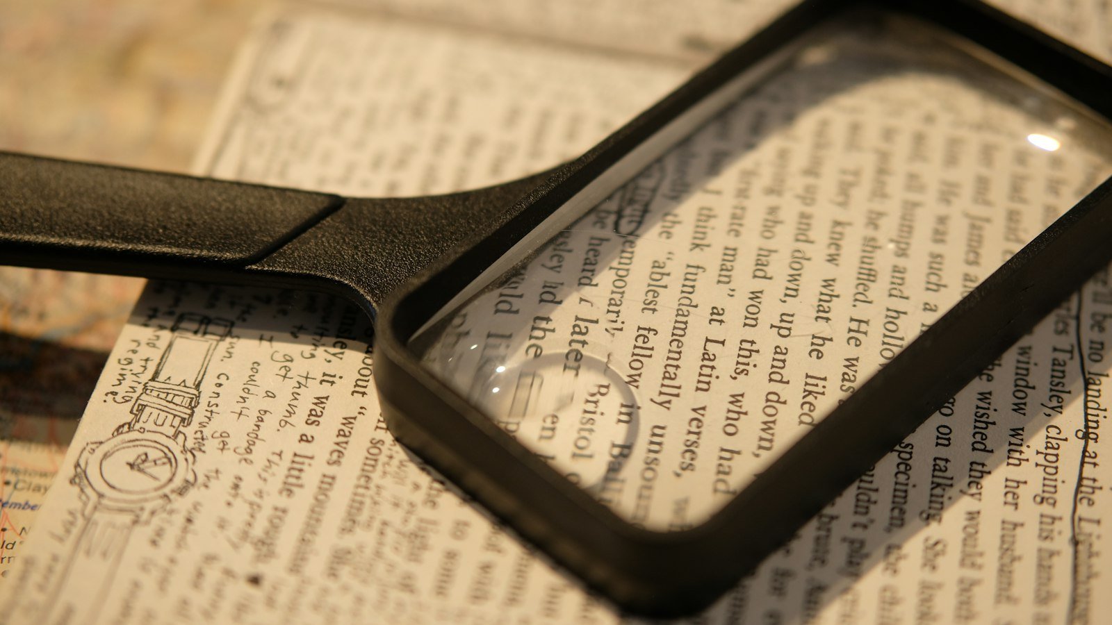 A magnifying glass resting on a folded newspaper