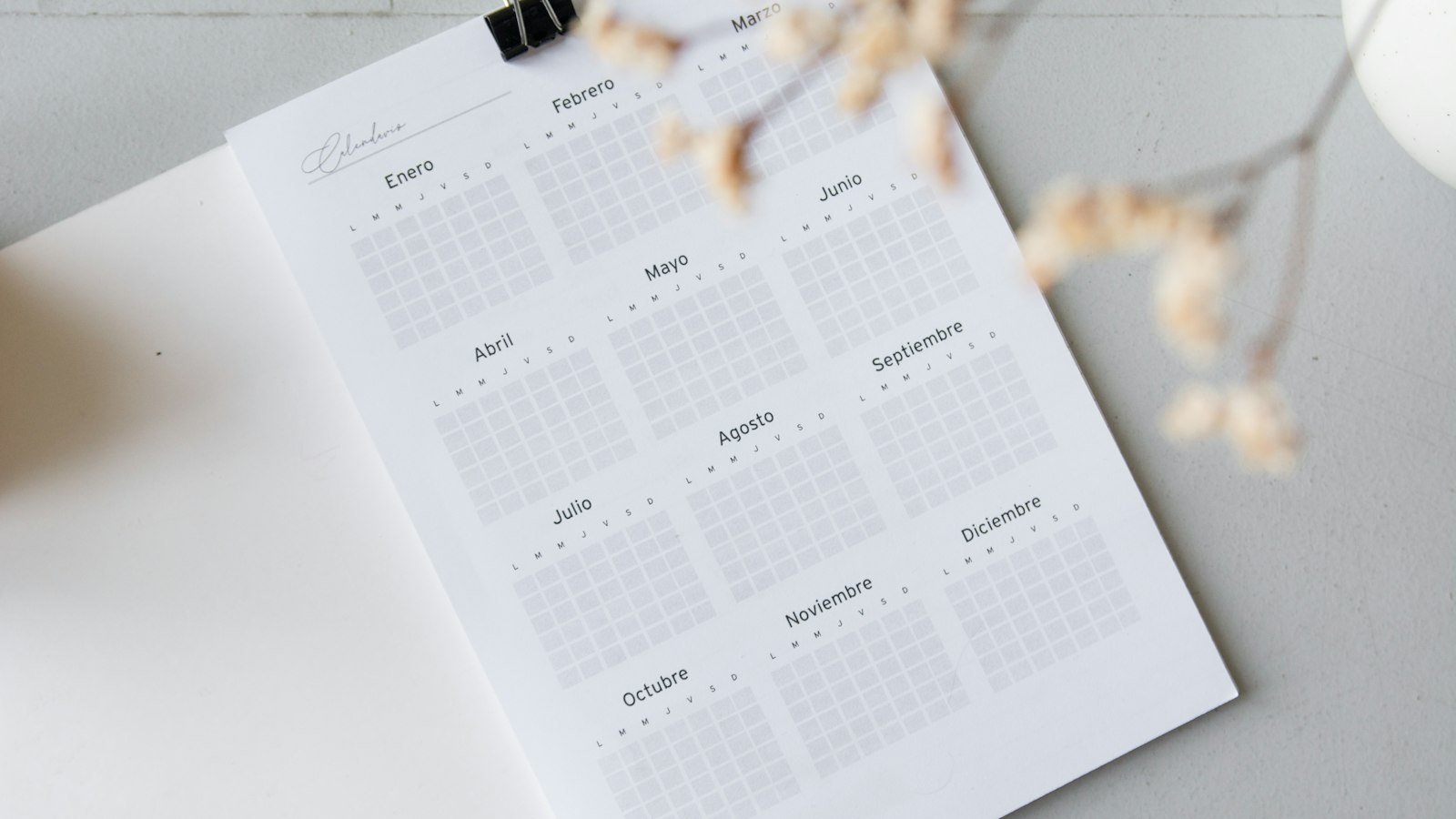 An open desk calendar and planner on a wooden table
