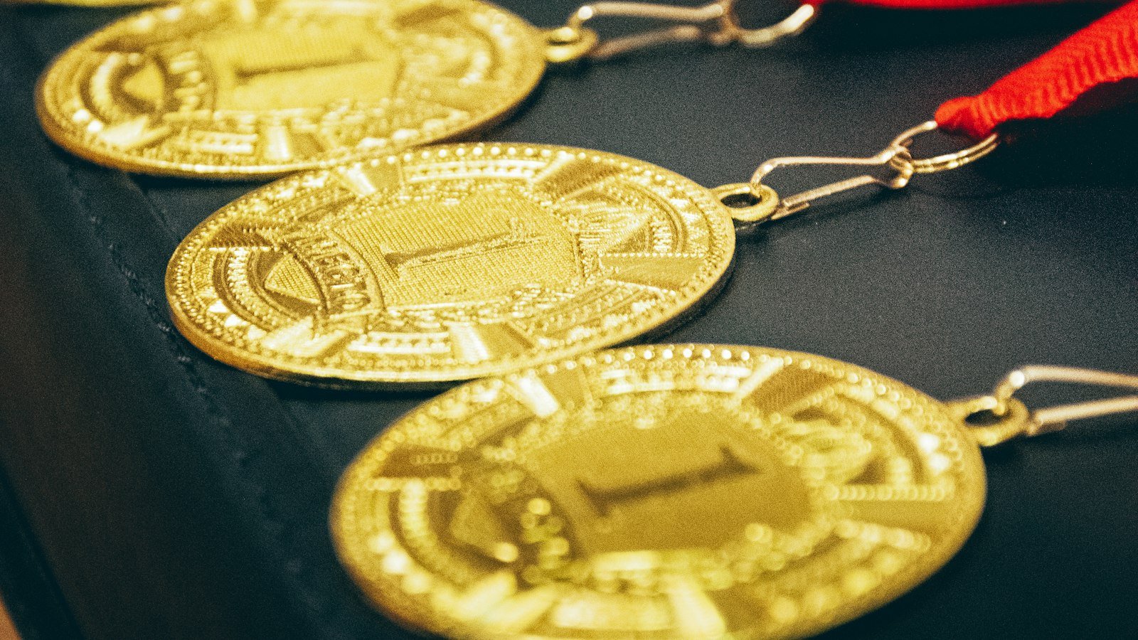 A row of gold medals with red ribbons