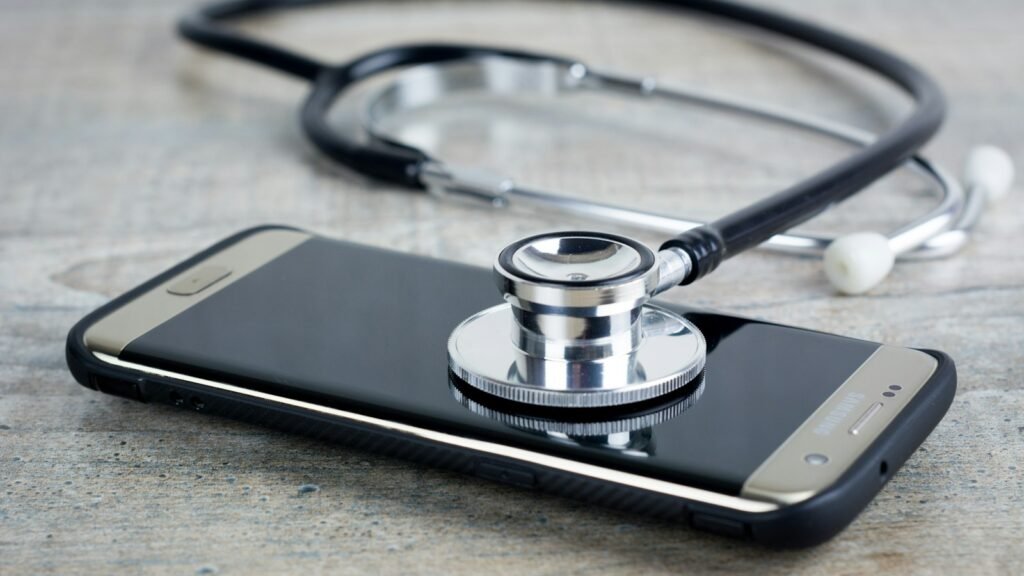 A smartphone lying on a desk beside a stethoscope