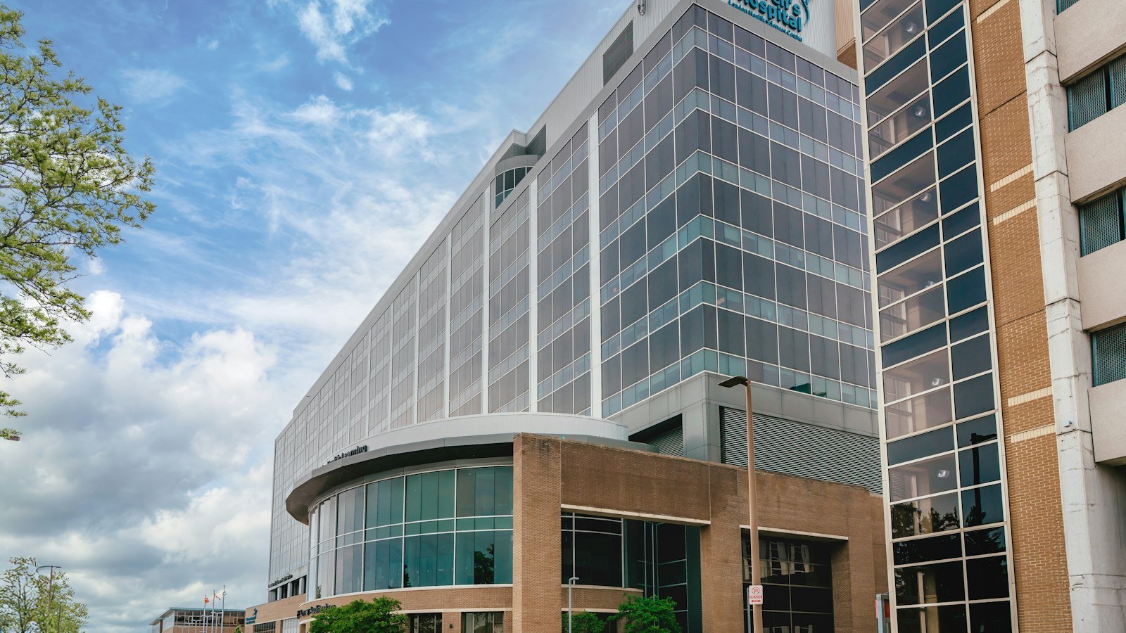 Modern glass hospital building with a curved entrance