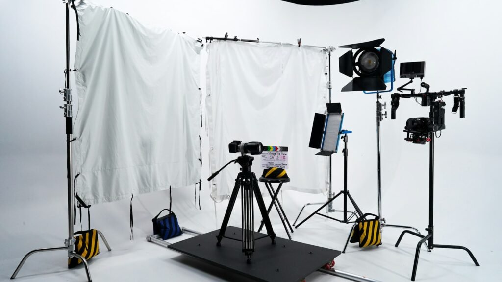 A video camera on a tripod in a softly lit studio