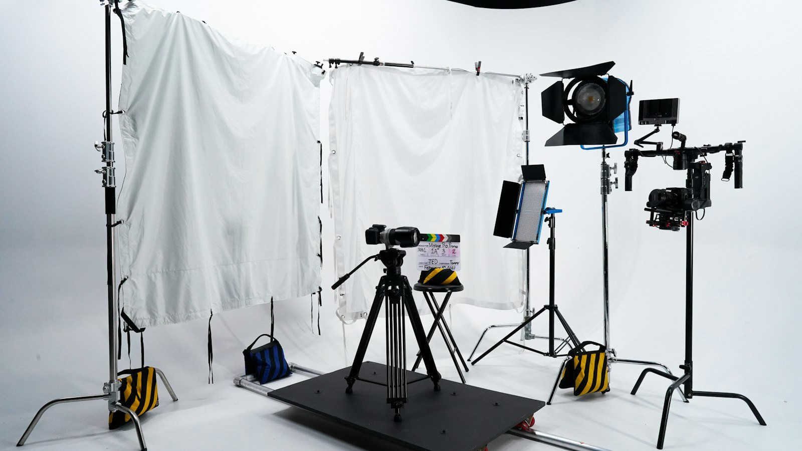 A video camera on a tripod in a softly lit studio