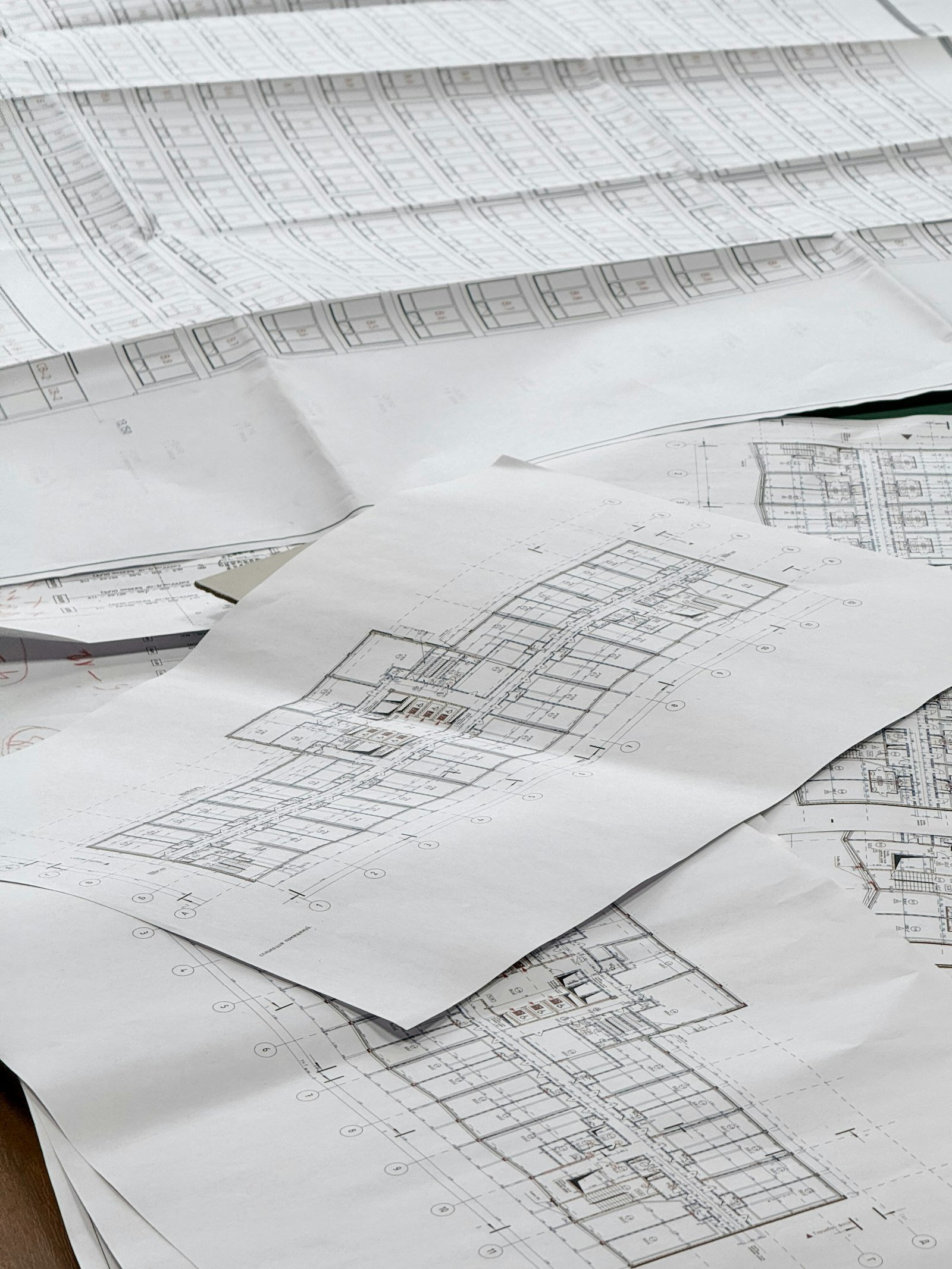 Stacked architectural blueprints on a desk