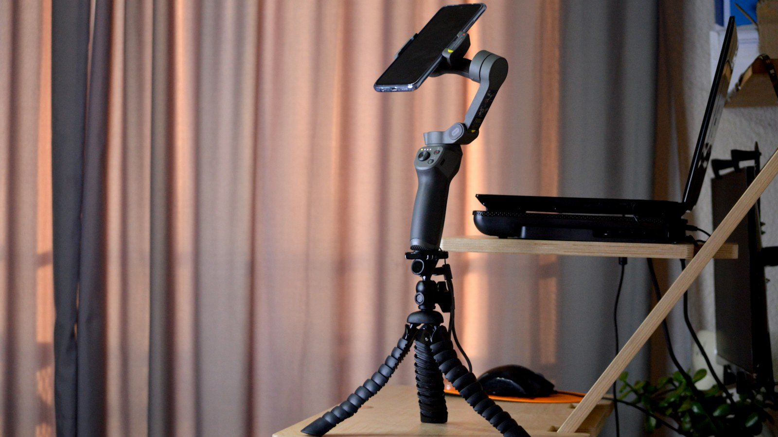 A camera mounted on a tripod set up beside a window