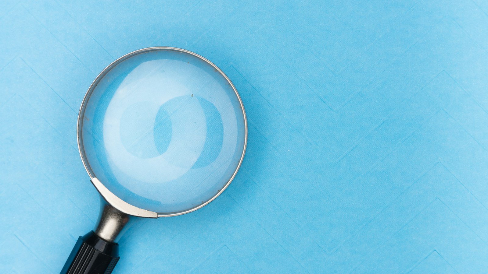 Magnifying glass over printed text, representing AI Overview optimisation