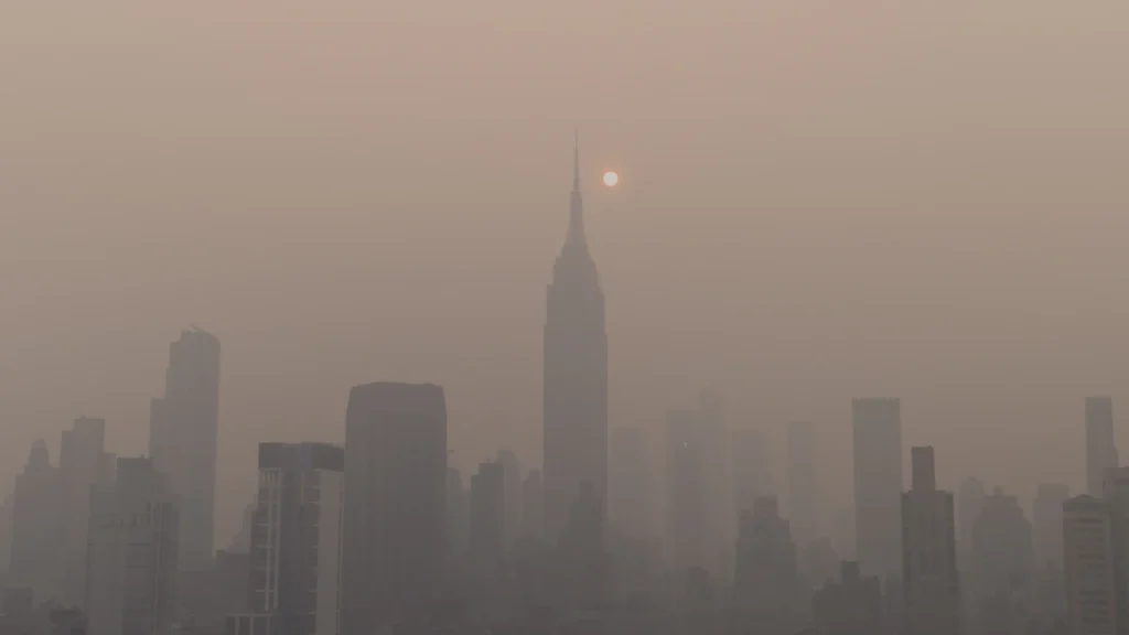 City skyline under a haze of smog with the sun low in the sky