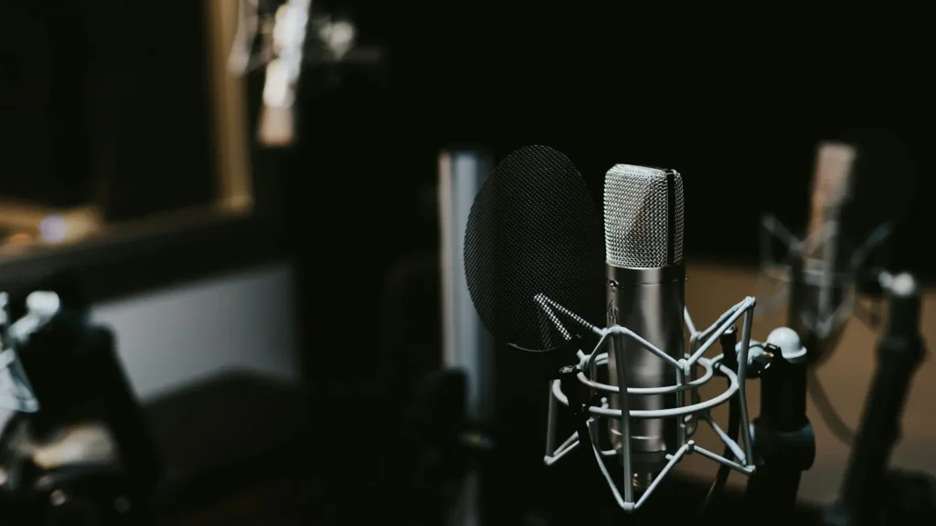 A broadcast microphone on a desk in an empty radio studio