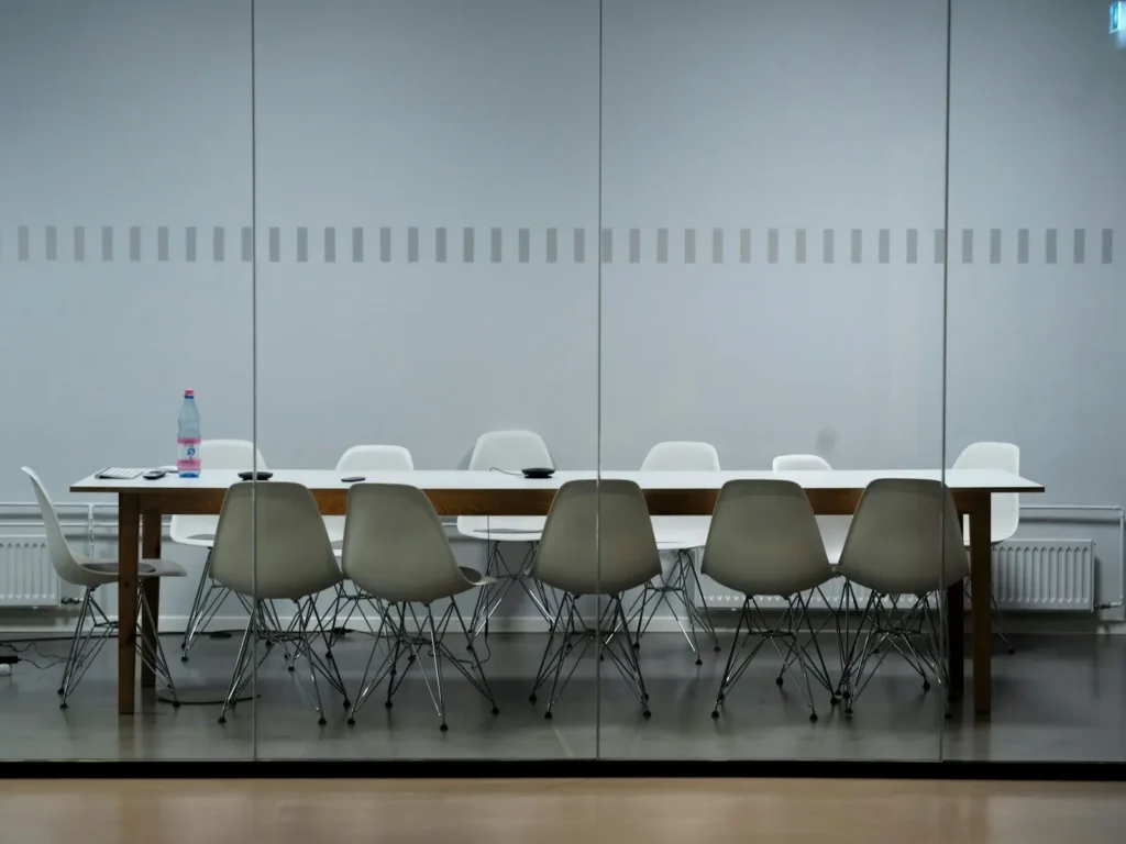 Empty glass boardroom with a long table and city skyline, representing the hospital CMO seat