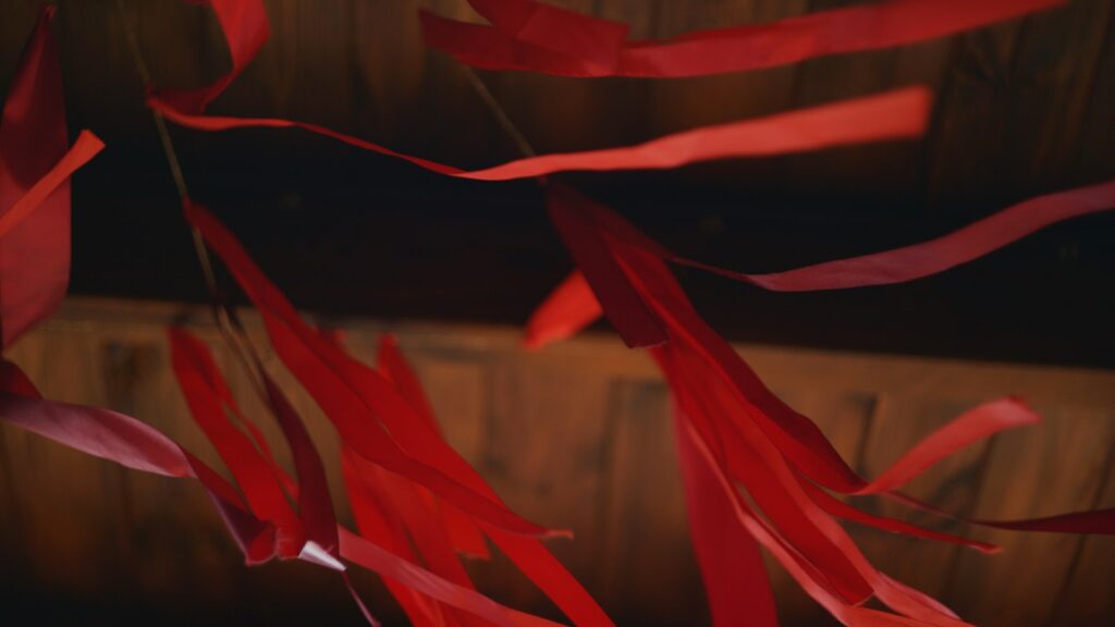 Red ribbons fluttering against a wooden background