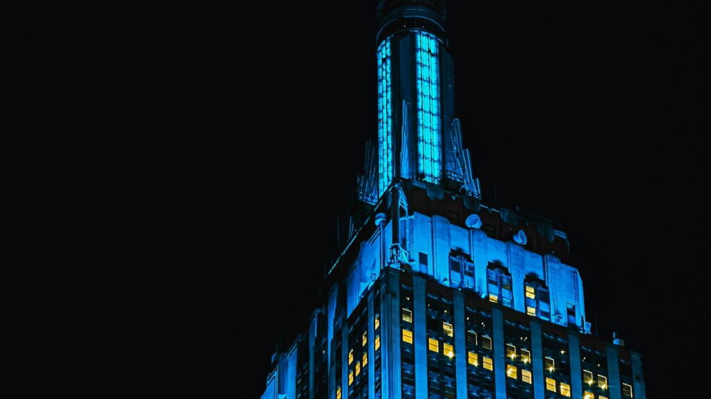 A tall building lit up with blue lights at night