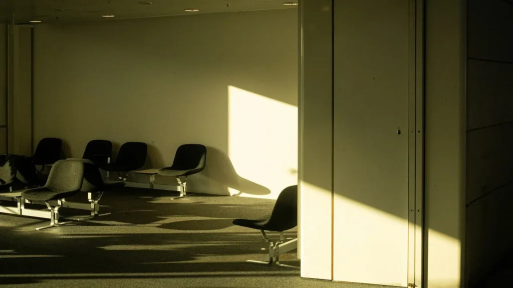 Empty seats in a quiet waiting area lit by afternoon sun