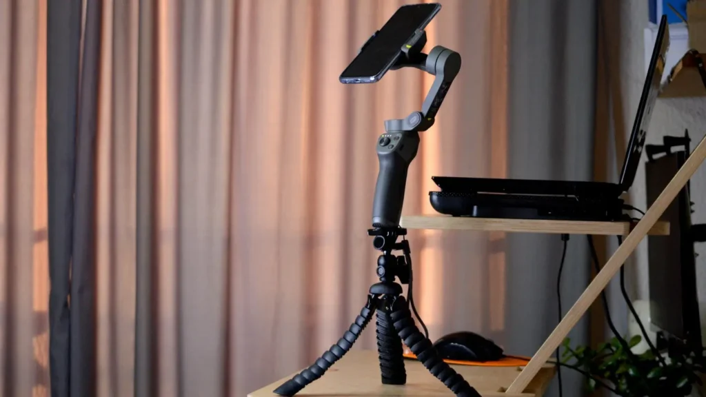 A camera mounted on a tripod set up beside a window